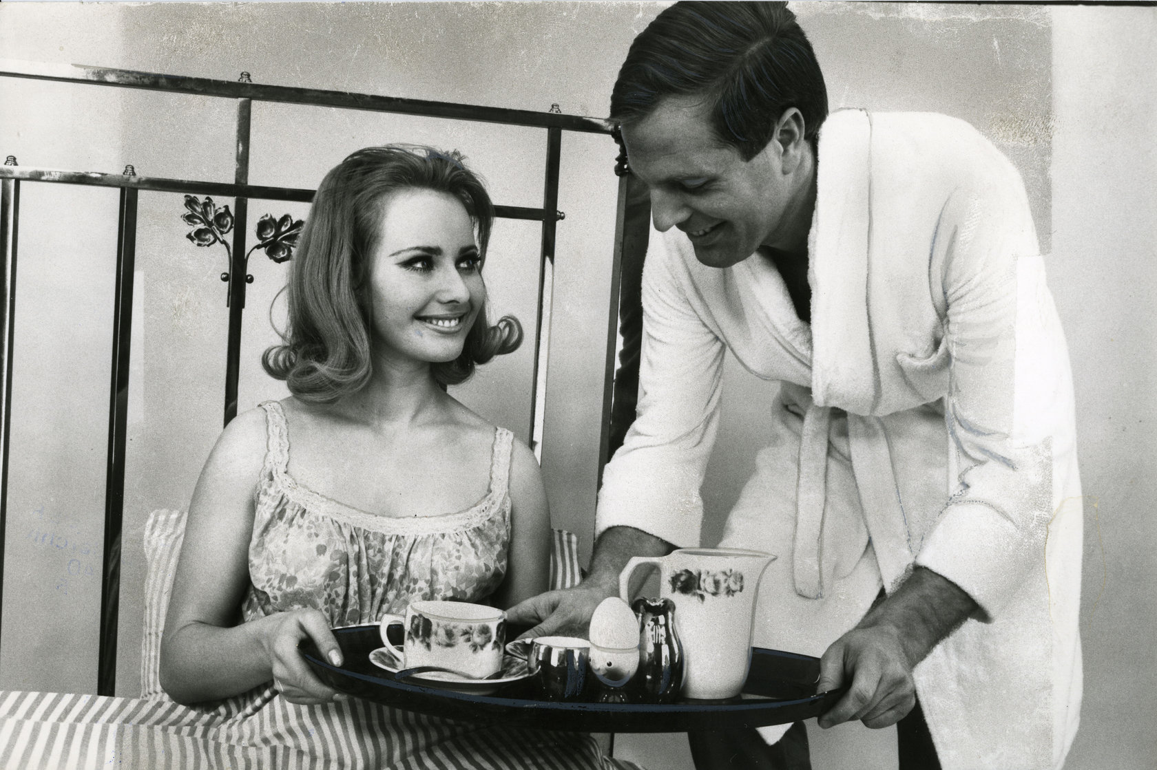 Schwarz-Weiß-Foto aus dem Photo Archiv Schweitzer: Mann im Badeanzug serviert Frau Frühstück ans Bett