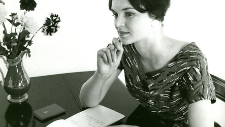 Schwarz-Weiß-Foto aus Photo Archiv Schweitzer: Frau sitzt am Tisch mit Stift und Block, grübelnd 
