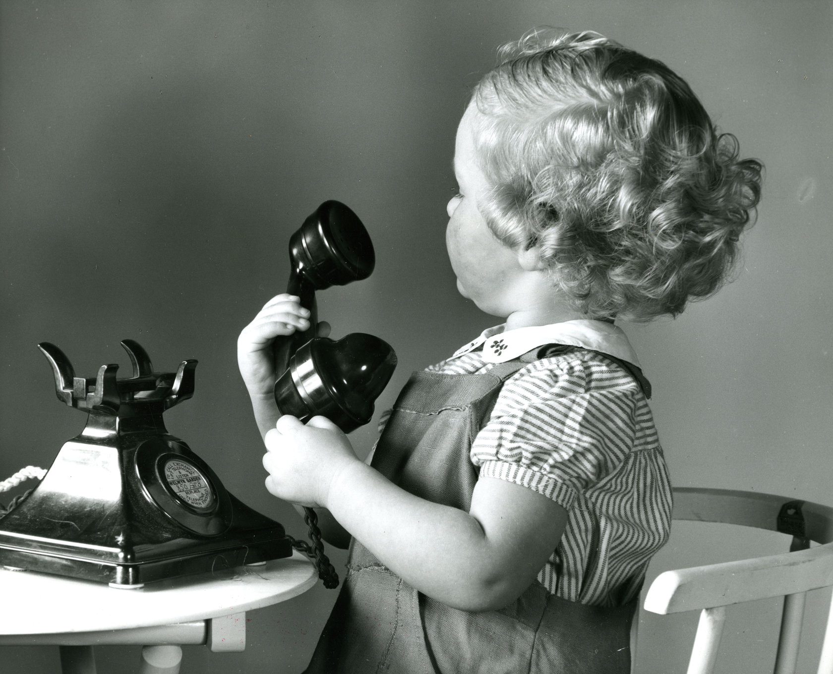 Schwarz-Weiß-Foto aus dem Foto Archiv Schweitzer: kleines Mädchen mit Telefonhörer in der Hand