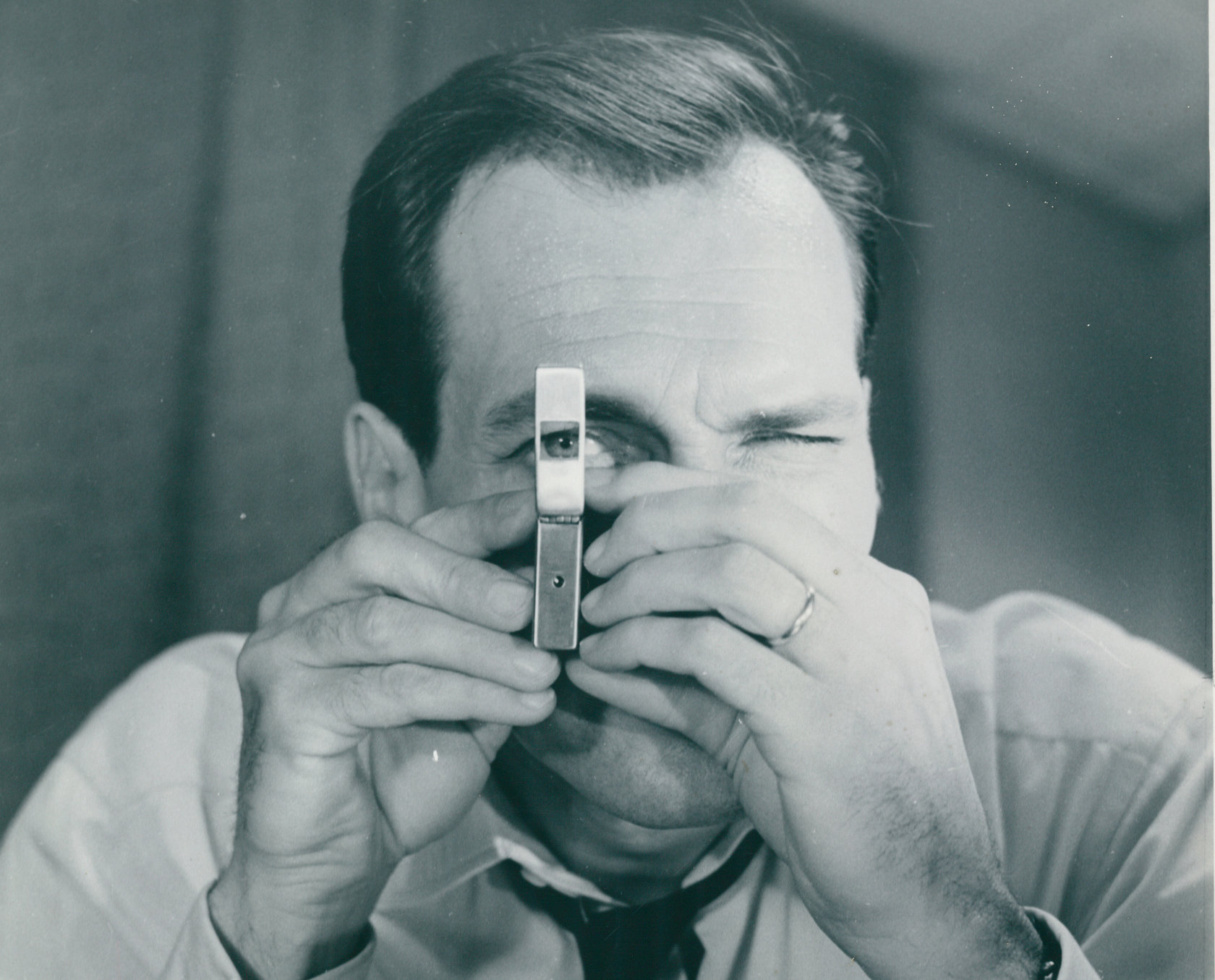 Schwarz-Weiß-Foto aus dem Photo Archiv Schweitzer: Mann schaut durch winzige Lupe