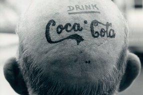 Schwarz-Weiß-Foto aus dem Photo Archiv Schweitzer: Glatze von hinten mit Aufschrift Coca Cola