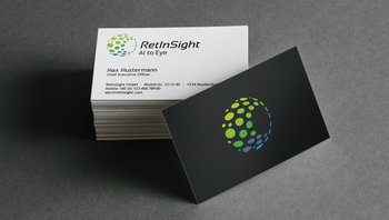 Stapel mit RetInSight Visitenkarten - eine Karte lehnt umgedreht am Stapel und zeigt die elegante schwarze Rückseite.